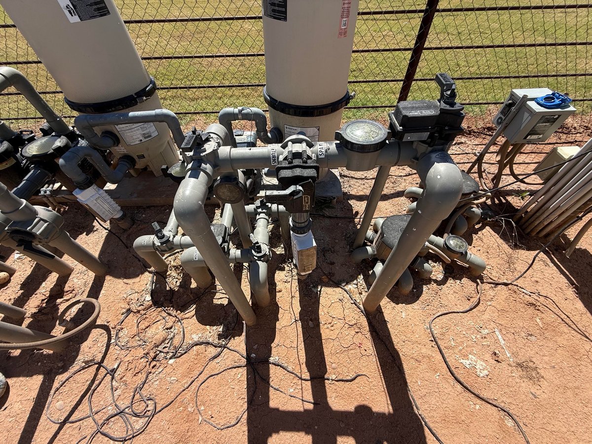 Pool equipment pad with multiple valve assemblies, pressure gauges, and piping